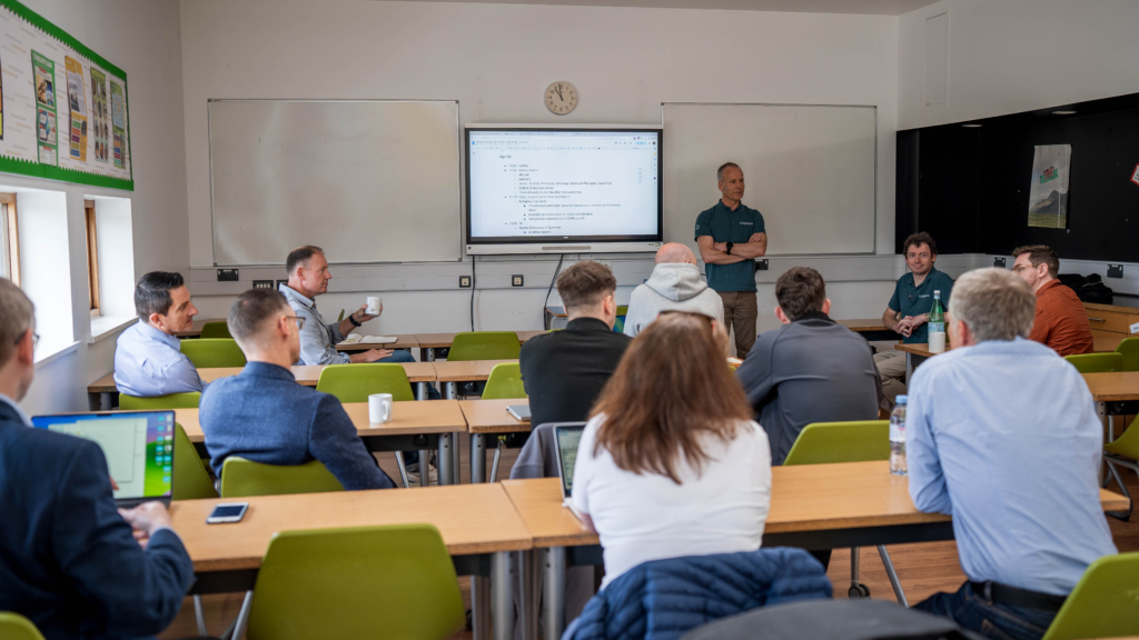 A dozen people in a classroom setting having a discussion